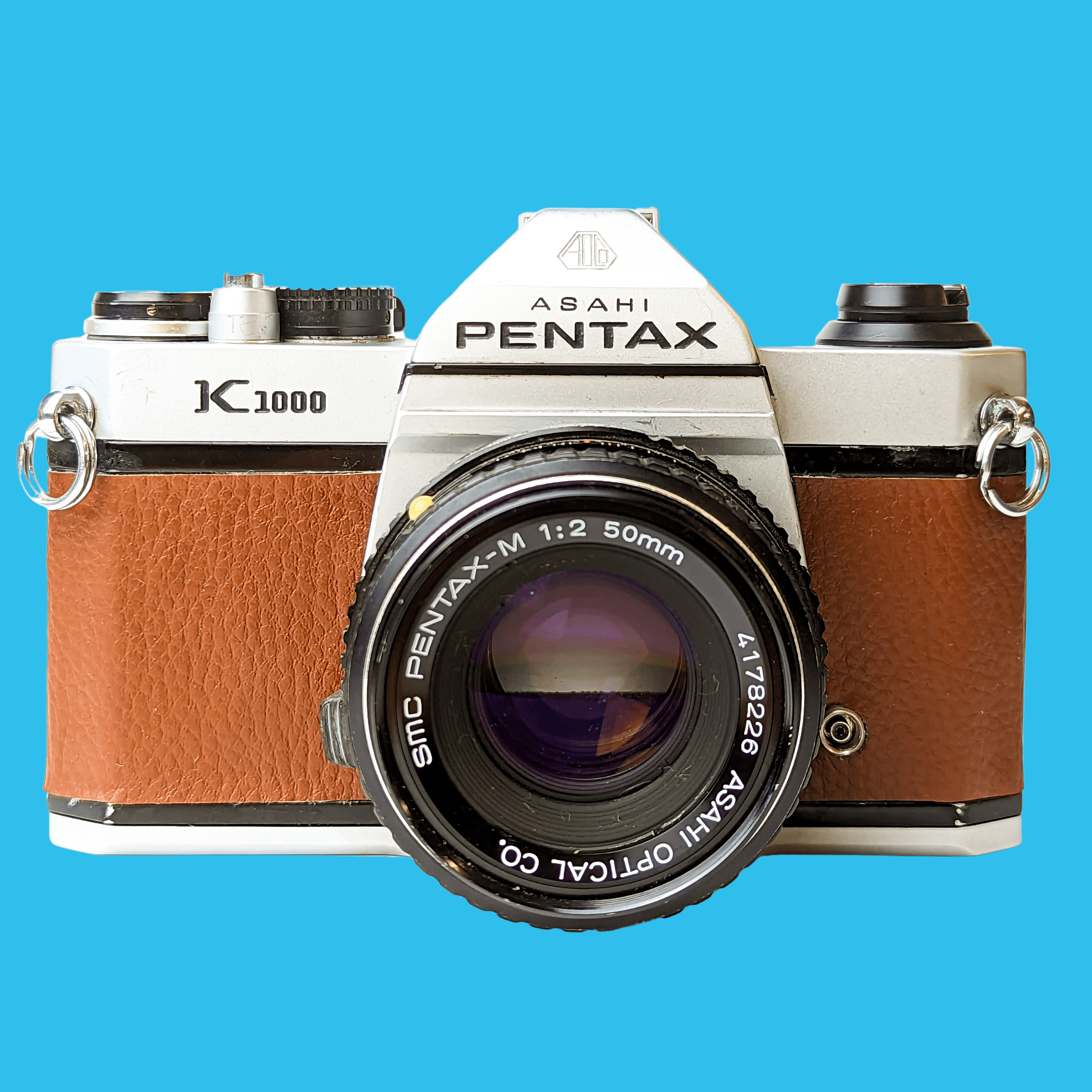 Pentax, Pentax K1000 Brown Leather Vintage SLR 35mm Film Camera with Pentax f/2 50mm Prime Lens.