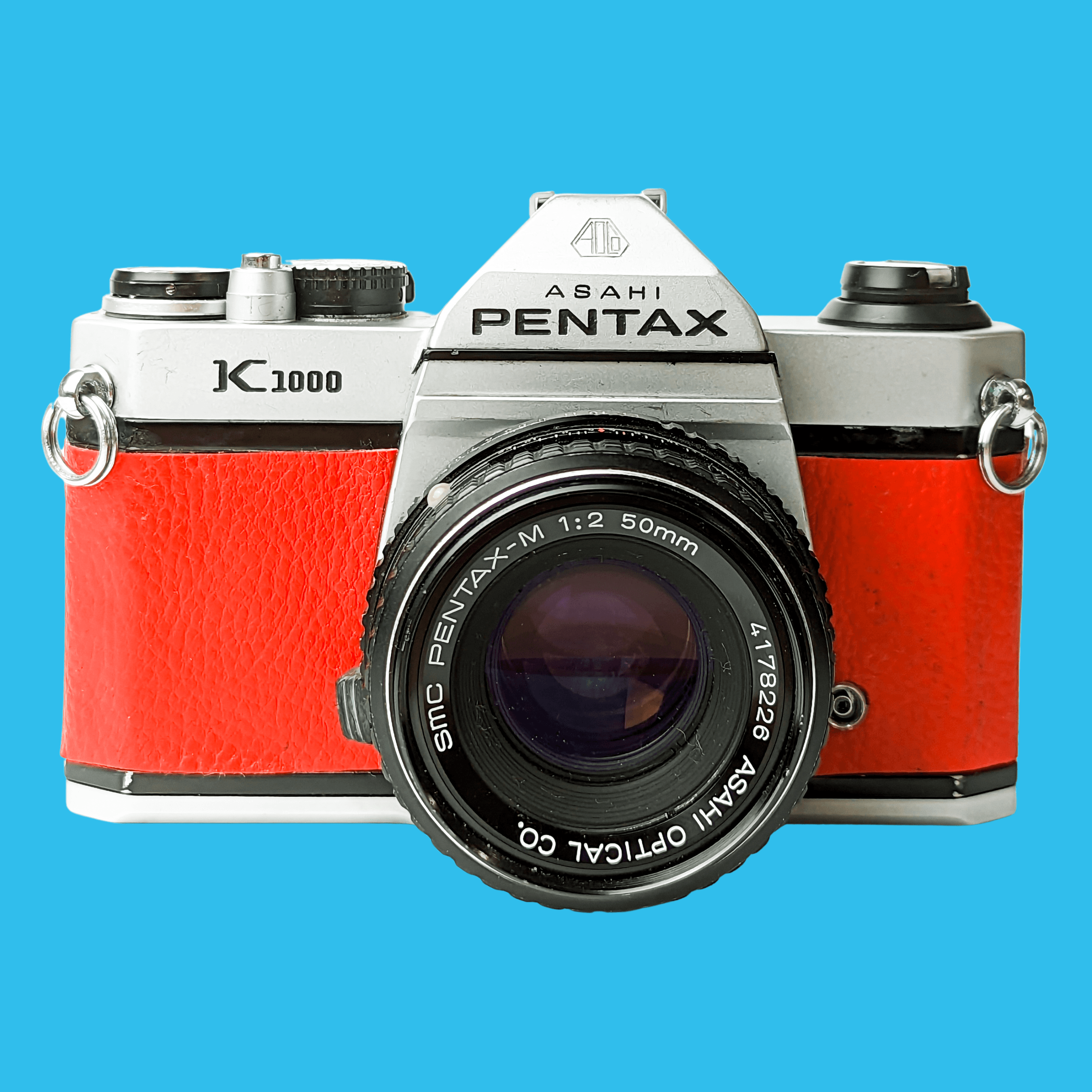 Ashai Pentax, Pentax K1000 Caméra SLR 35mm Vintage en cuir rouge avec objectif Pentax f/2 50mm.